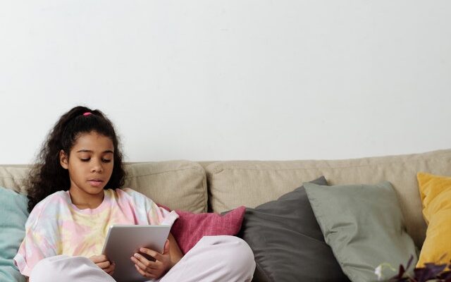 photo-of-girl-sitting-on-sofa-while-using-tablet-4144040